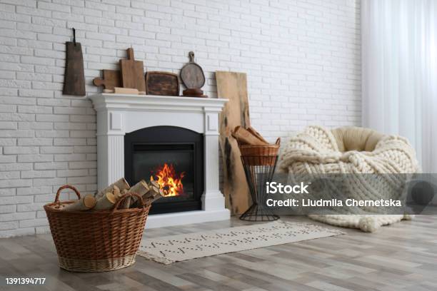 Wicker Baskets With Firewood And White Fireplace In Cozy Living Room Stock Photo - Download Image Now