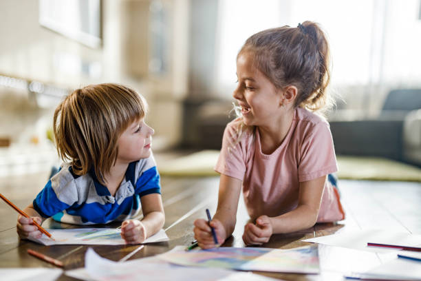 istock Happy little kids talking while drawing on floor at home. 1391397617