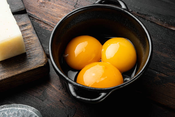 Bright yellow egg yolks, on old dark  wooden table