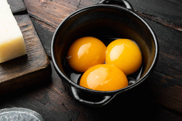 Bright yellow egg yolks, on old dark  wooden table Bright yellow egg yolks set, on old dark  wooden table egg yolk stock pictures, royalty-free photos & images