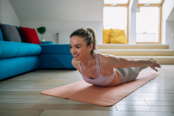 istock Woman practicing yoga at home and doing Double Leg Kicks pose. 1391399089