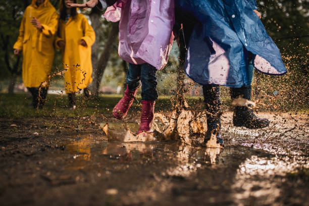 istock Unrecognizable kids running through muddy puddle in nature. 1391399999