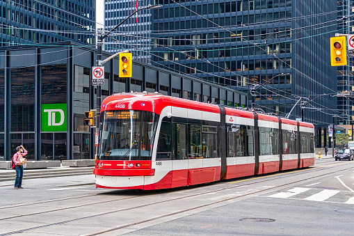 Toronto, Canada - July 8, 2021: Modern Bombardier Flexity Outlook streetcar driving in King Street in the downtown district. The TTC is the largest public transportation system in the country.