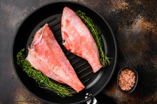 fresh sea ocean red perch fish, in frying cast iron pan, on old dark rustic table background, top view flat lay - rockfish imagens e fotografias de stock
