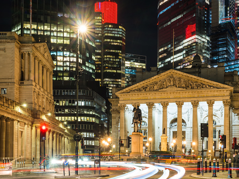 The Bank of England and skyscrapers of the City of London Square Mile financial district illuminated at night in the heart of London, the UK’s vibrant capital city.