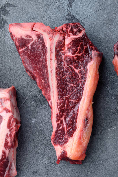 istock Prime cut tender raw t-bone steak for a BBQ, on gray stone background, top view flat lay 1391403679