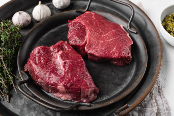 istock Beef raw rump steak with salt pepper rosemary, on white stone table background 1391405186