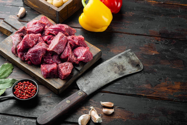 istock Fresh beef chunks served on table with ingredients ready for cooking with sweet bell pepper, on old dark  wooden table , with copy space for text 1391406387