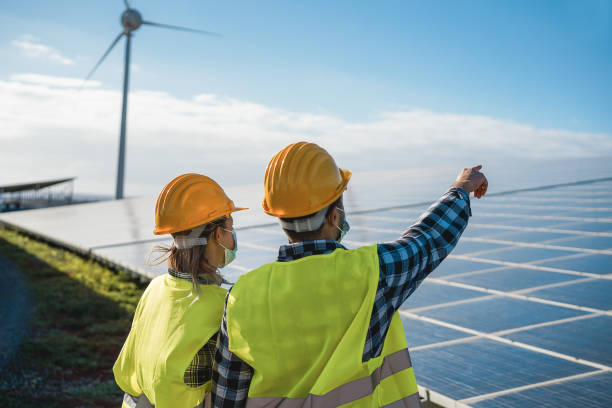 les personnes travaillant pour les panneaux solaires et les éoliennes dans les fermes d’énergie renouvelable portant des masques de sécurité - focus sur le casque de femme - solar panel engineer solar power station women photos et images de collection