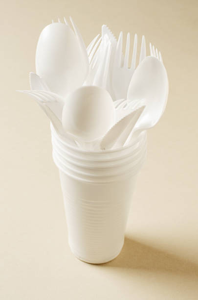 istock Disposable white plastic tableware on a beige background. The concept of nature pollution 1391407462