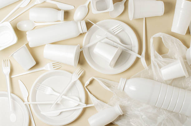 istock Disposable white plastic tableware on a beige background. The concept of nature pollution 1391407465
