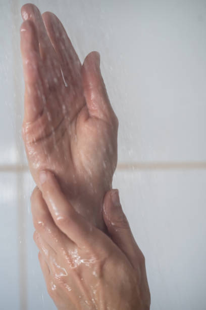 istock Female hands touching the water in bathroom 1391409759