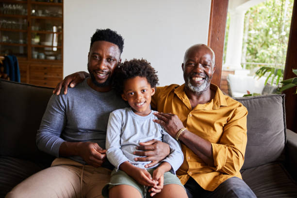 istock man and his senior dad and young son smiling while sitting at home 1391410195