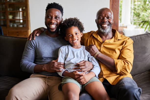 istock Man and his senior dad and young son sitting on a sofa and laughing 1391410246