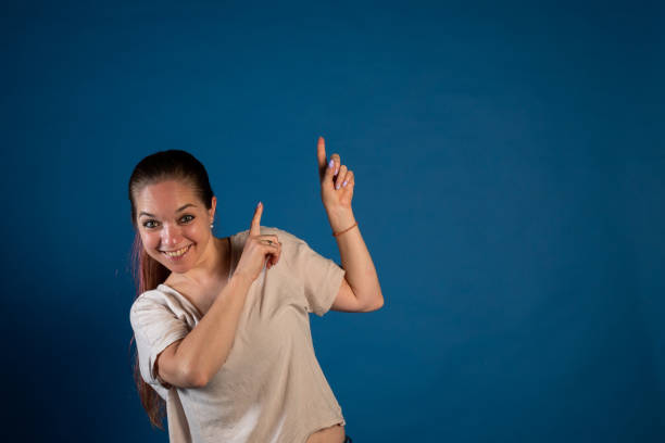 Young woman pointing her fingers up. Photo reaction. Photography for advertising. Copyspace. Woman pointing something up