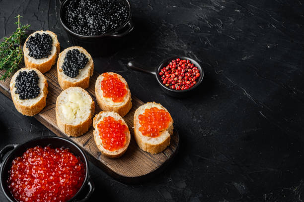 istock Sandwiches with red and black caviar    , on black background  with copy space for text 1391410500