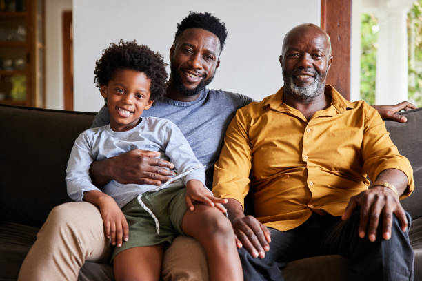 istock Man and his senior dad and young son smiling while sitting at home 1391411451