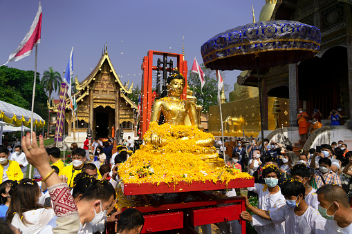 CHIANG MAI THAILAND - APRIL 13 : Chiangmai Songkran festival.The tradition of bathing the Buddha Phra Singh on the parade cars for pour water in Songkran Festival on April 13, 2022 in Chiangmai, Thailand.