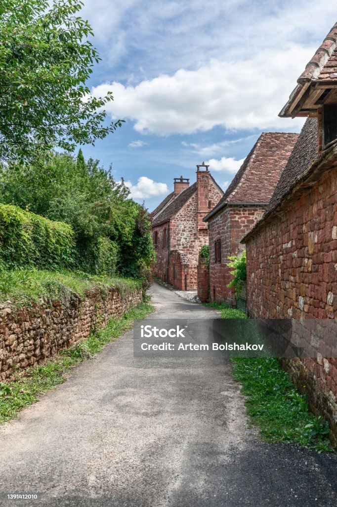 Street with perfectly preserved medieval residential masonry buildings on outskirts of Collonges-la-Rouge. Correze department, New Aquitaine region, France Cobblestone Stock Photo