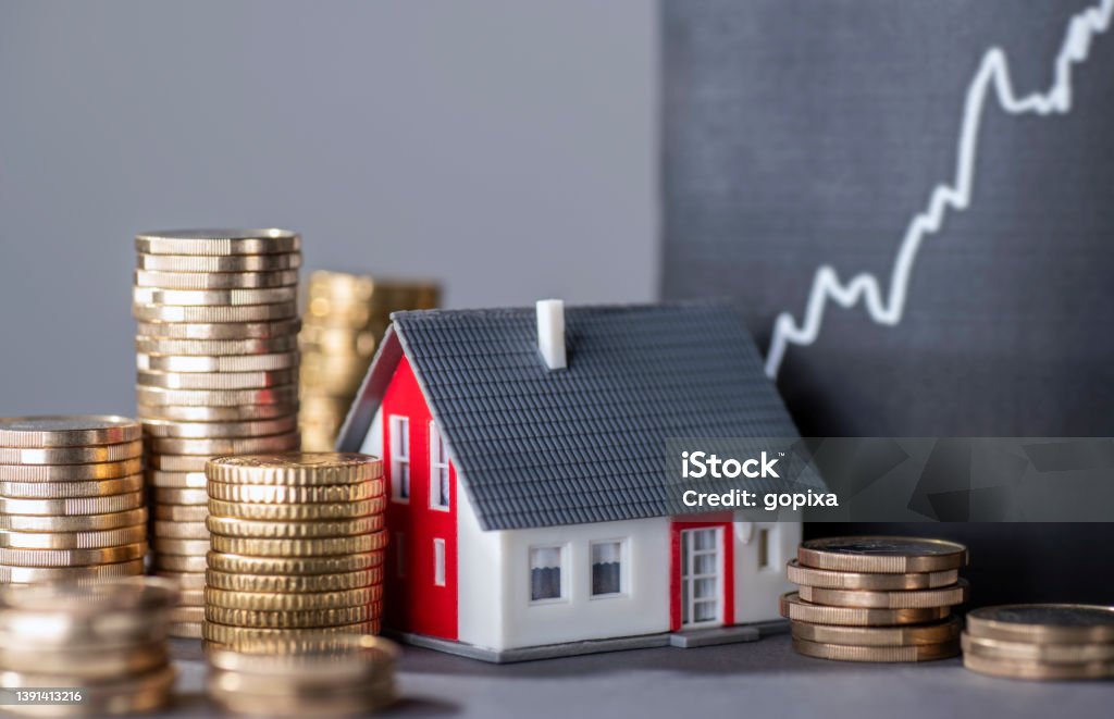 Rising prices for real estate House with stacks of money and a rising curve symbolizing rising real estate prices Mortgage Loan Stock Photo