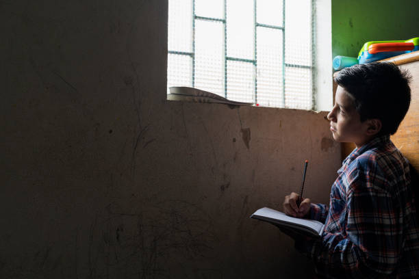 istock A low-income Hispanic boy, average age 11, is sitting in his room doing homework 1391415135