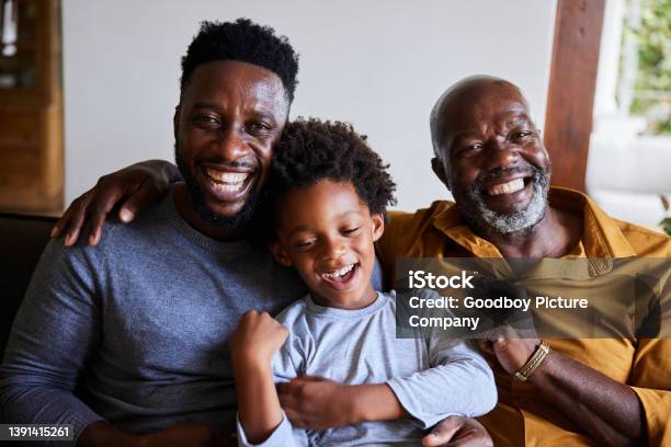 Man And His Senior Dad And Young Son Laughing Together On A Sofa Stock Photo - Download Image Now