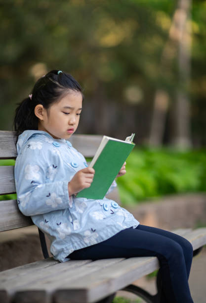 istock Little Girl Reading Book 1391415494