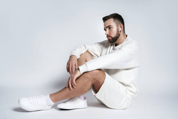 istock Handsome man wearing white sweatshirt and shorts with wireless earbuds sitting 1391422123