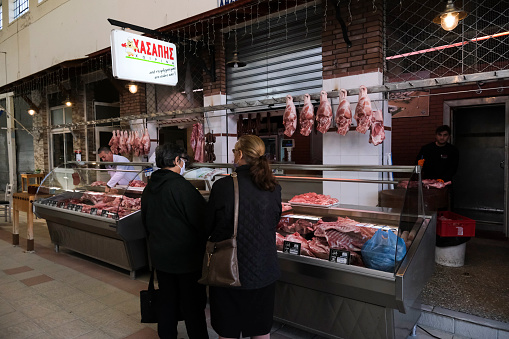 People make their way past butcheries displaying meat inside Xanthi's main meat market in Greece on Nov. 12, 2021.