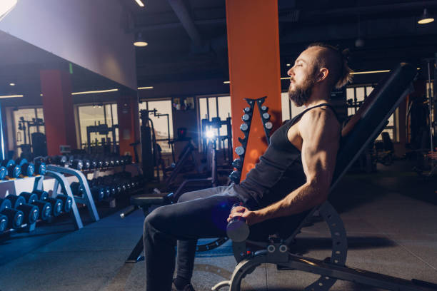 istock Athletic man doing exercise with dumbbells in the gym 1391426095