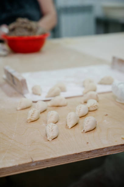 istock Dumplings with minced meat and dough on table sprinkled with flour. 1391436949