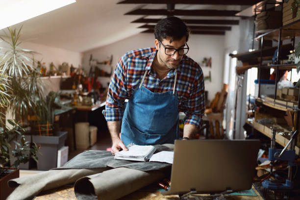 istock Male small business owner working on laptop at tailor leather workshop 1391438840