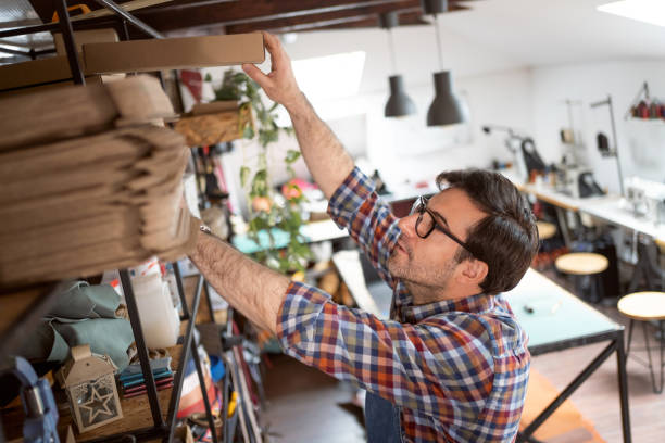 istock Male tailor arranging the cardboard boxes on the shelf 1391440084