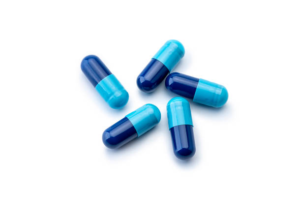 istock Medicine; Blue Capsules on white 1391441231