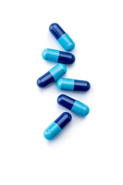 istock Medicine; Blue Capsules on white 1391441246