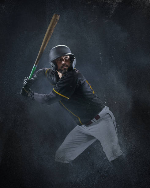 Creative portrait of professional baseball player in sports equipment getting ready to hit isolated on smoked background. Sport, art, action, hobby concept stock photo