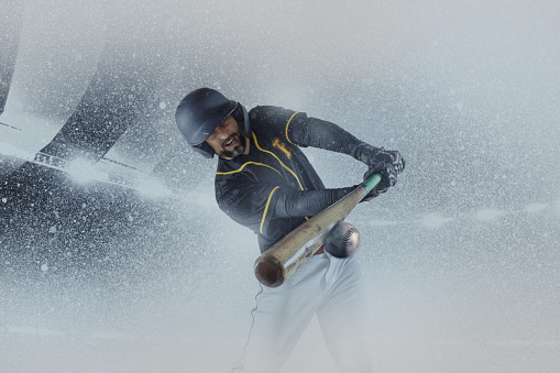 Winter games. One professional baseball player in sports equipment training alone isolated on a snowy background. Sport, art, action, hobby concept. Poster, flyer with sportive man