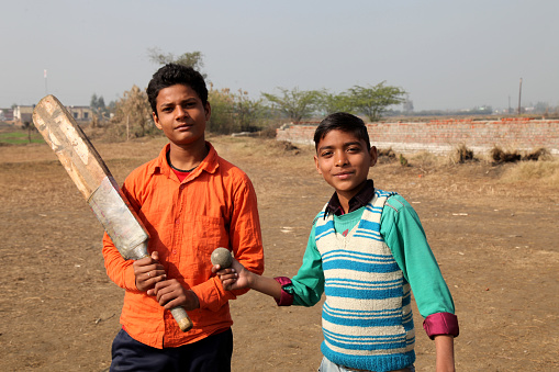 Village boy playing cricket standing portrait together in the playground.