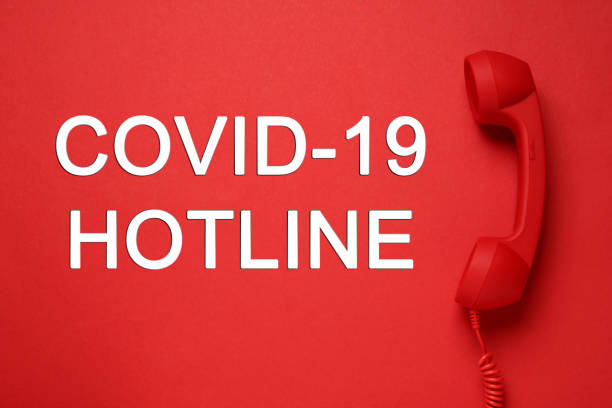 istock Covid-19 Hotline. Handset and text on red background, top view 1391445849