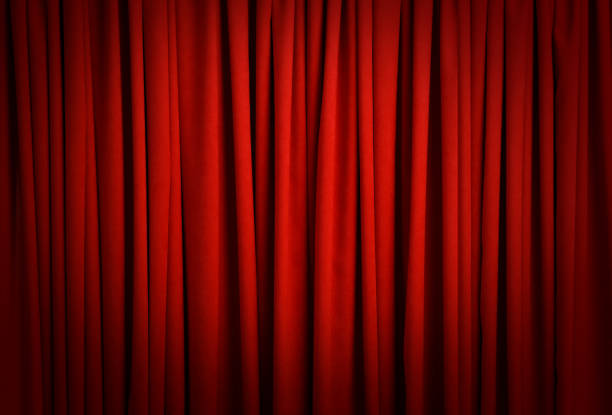 istock Spotlight illuminating closed red stage curtains. Start of performance 1391445874