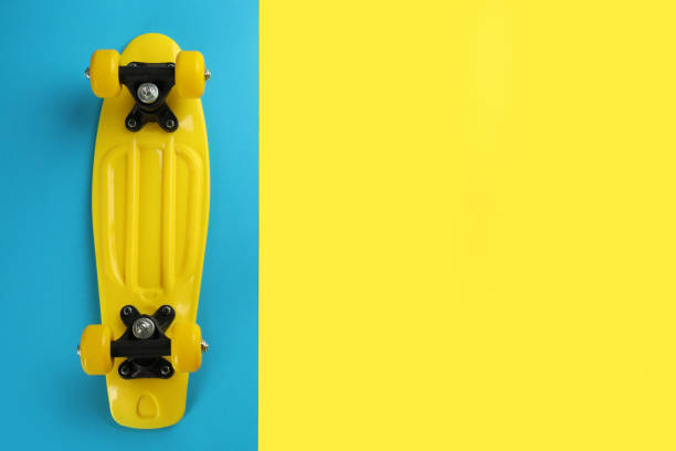 istock Yellow skateboard on color background, top view. Space for text 1391446015