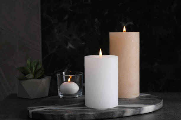 istock Marble board with burning candles on dark table 1391446052