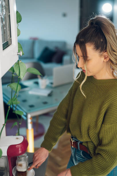 istock Woman using coffee machine and having a cup of coffee at home 1391448219