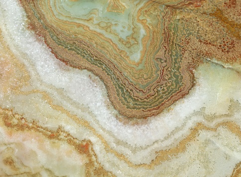 Onyx marble stone , crossed cut. Colors are white, brown green, red and golden. Texture and background.