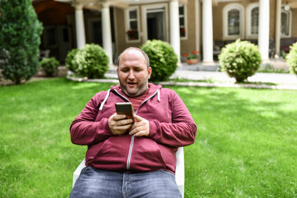 istock Relaxation Time For Smiling Male Using Smartphone While Sitting On Home Park 1391449825