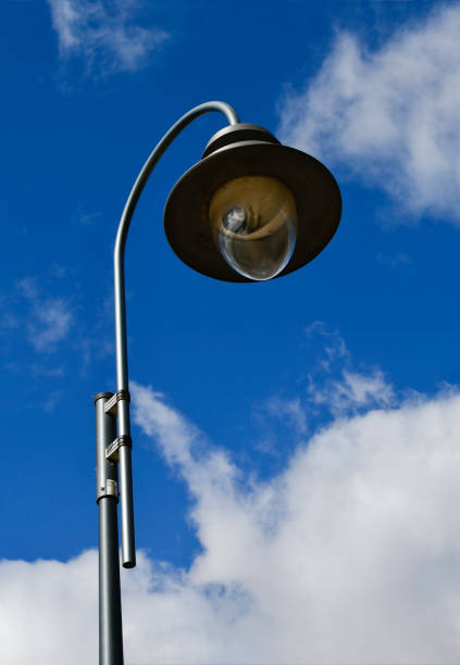 Street lamp. A large lamp against a cloudy blue sky. Lantern close-up.