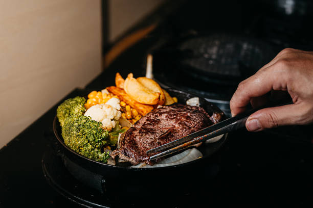 istock Chef cooking beef steak in the kitchen 1391450784