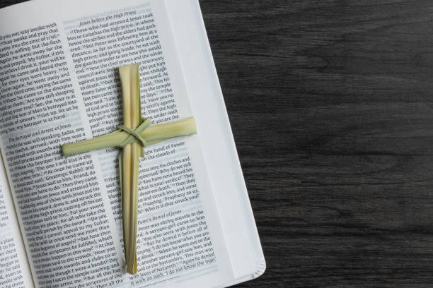 istock Close up palm leaf cross on open bible 1391453685