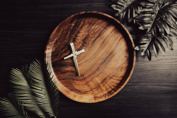 istock Dried palm cross on circular teak tray with palms frame 1391453694