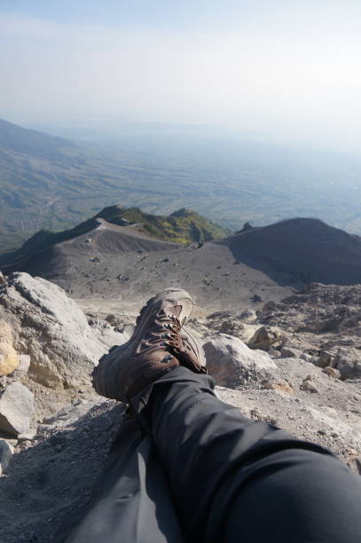 istock Hiker looking down from rock in landscape. 1391454731